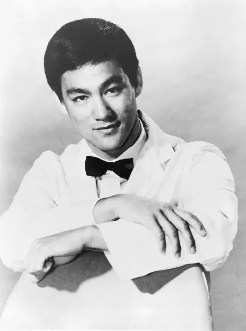 Bruce Lee in the black chauffeur's uniform, cap and mask of Kato in a publicity photograph for The Green Hornet.