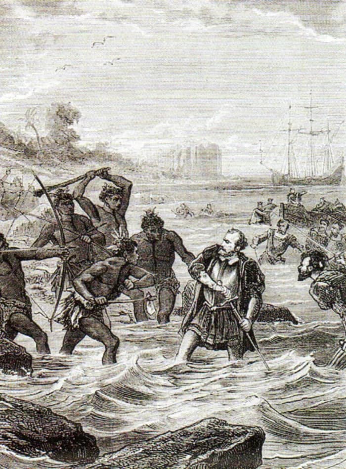 19th-century engraving showing Magellan surrounded by Mactan warriors with spears and blades as he falls in shallow water.