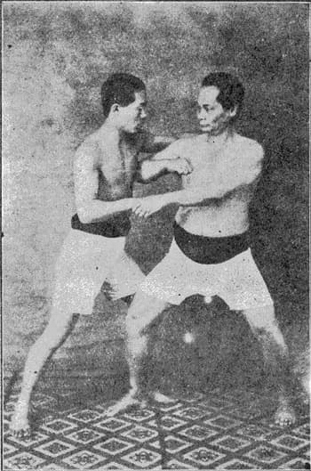 Photograph from 1926 of Motobu Chōki demonstrating a kumite technique against a partner.