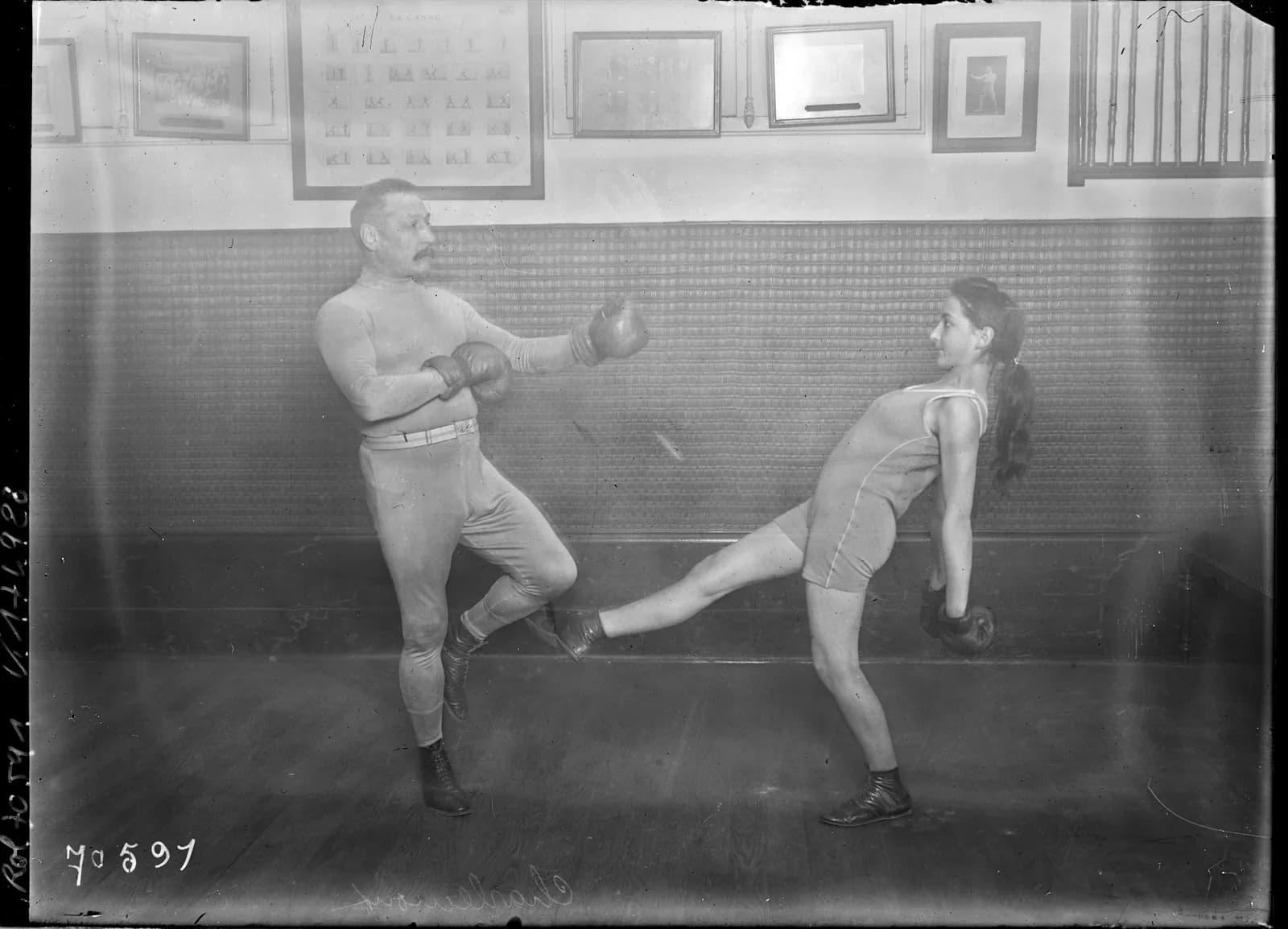 Photograph from 1921 of Charles Charlemont training a woman in boxe française in a gymnasium.